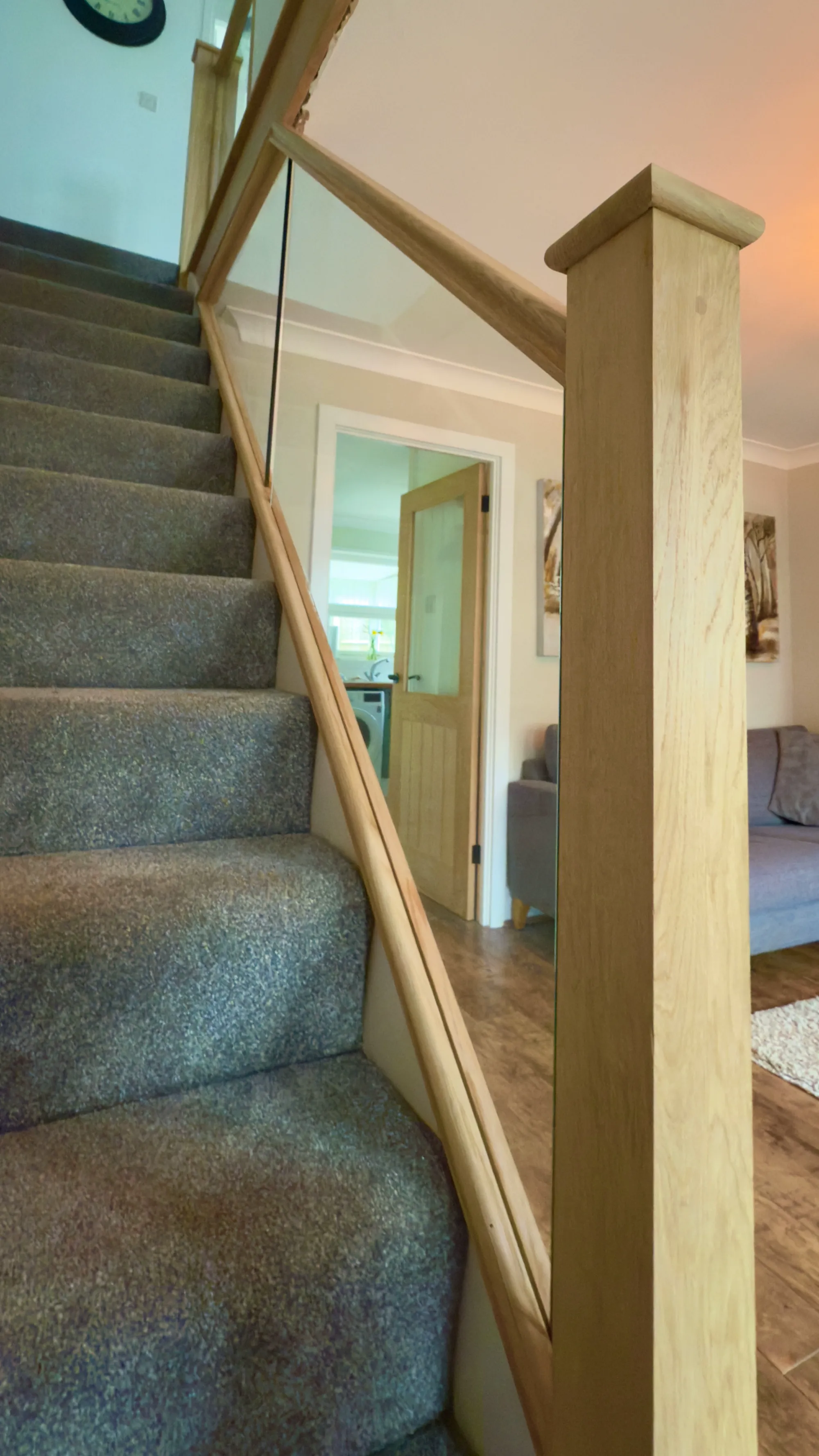 Bespoke staircase renovation with oak newel post, handrail, and glass balustrade. Modern staircase upgrade by Kent staircase specialists.