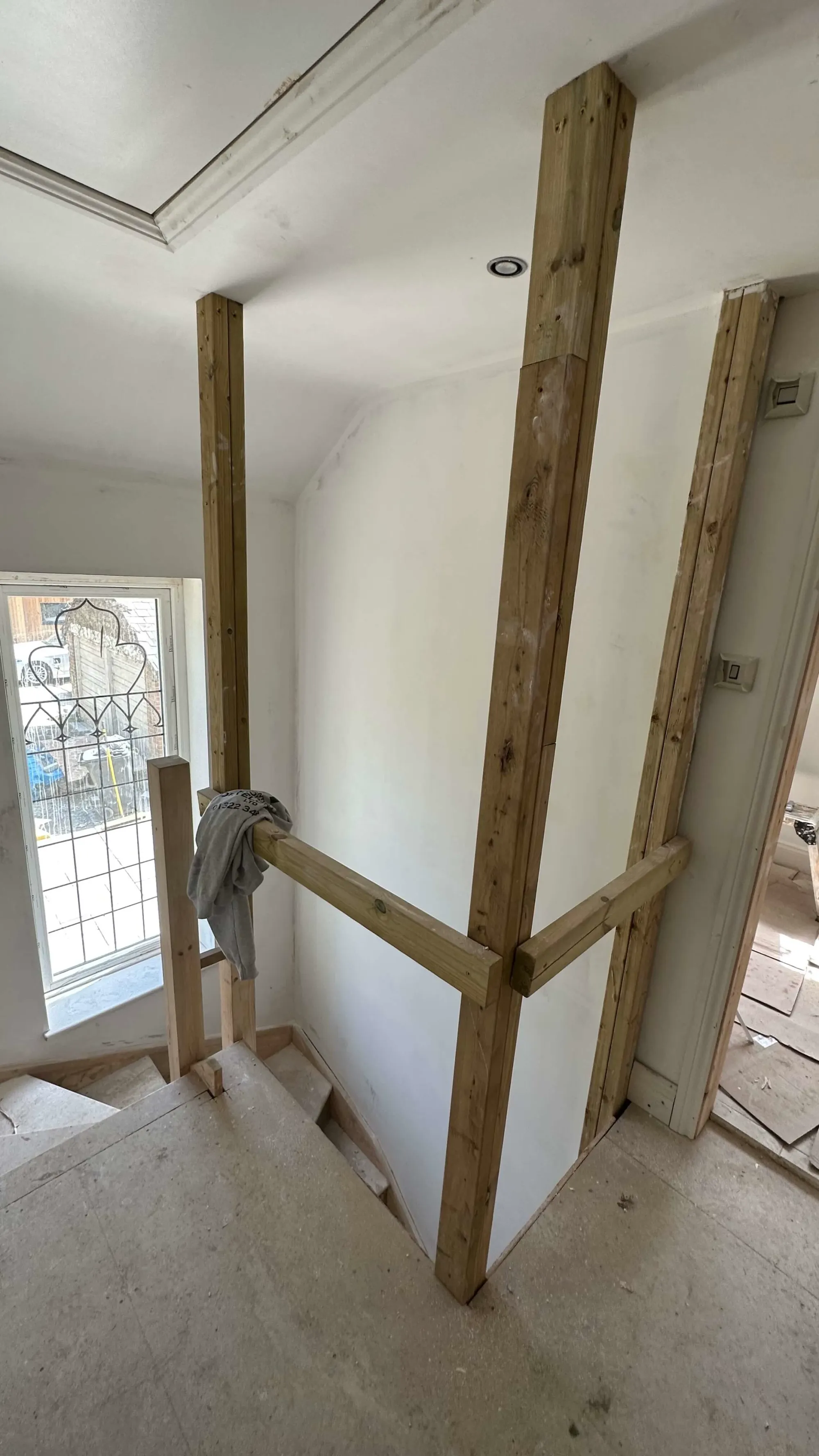 Staircase renovation in progress with temporary wooden framing for new balustrades, part of a bespoke staircase refurbishment.