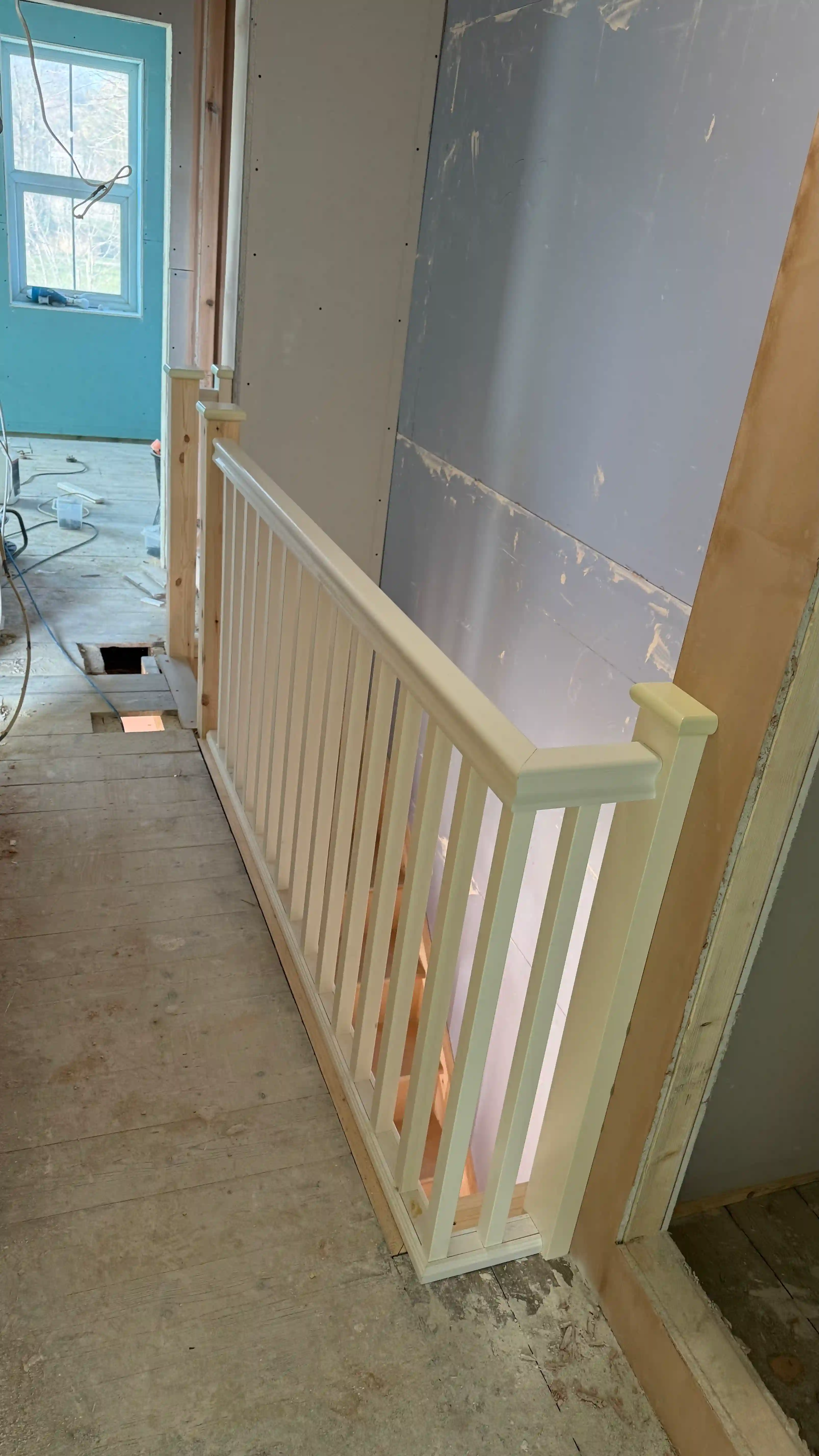 Upper floor balustrade with white wooden spindles and handrail overlooking the staircase. Staircase safety and design in Kent.