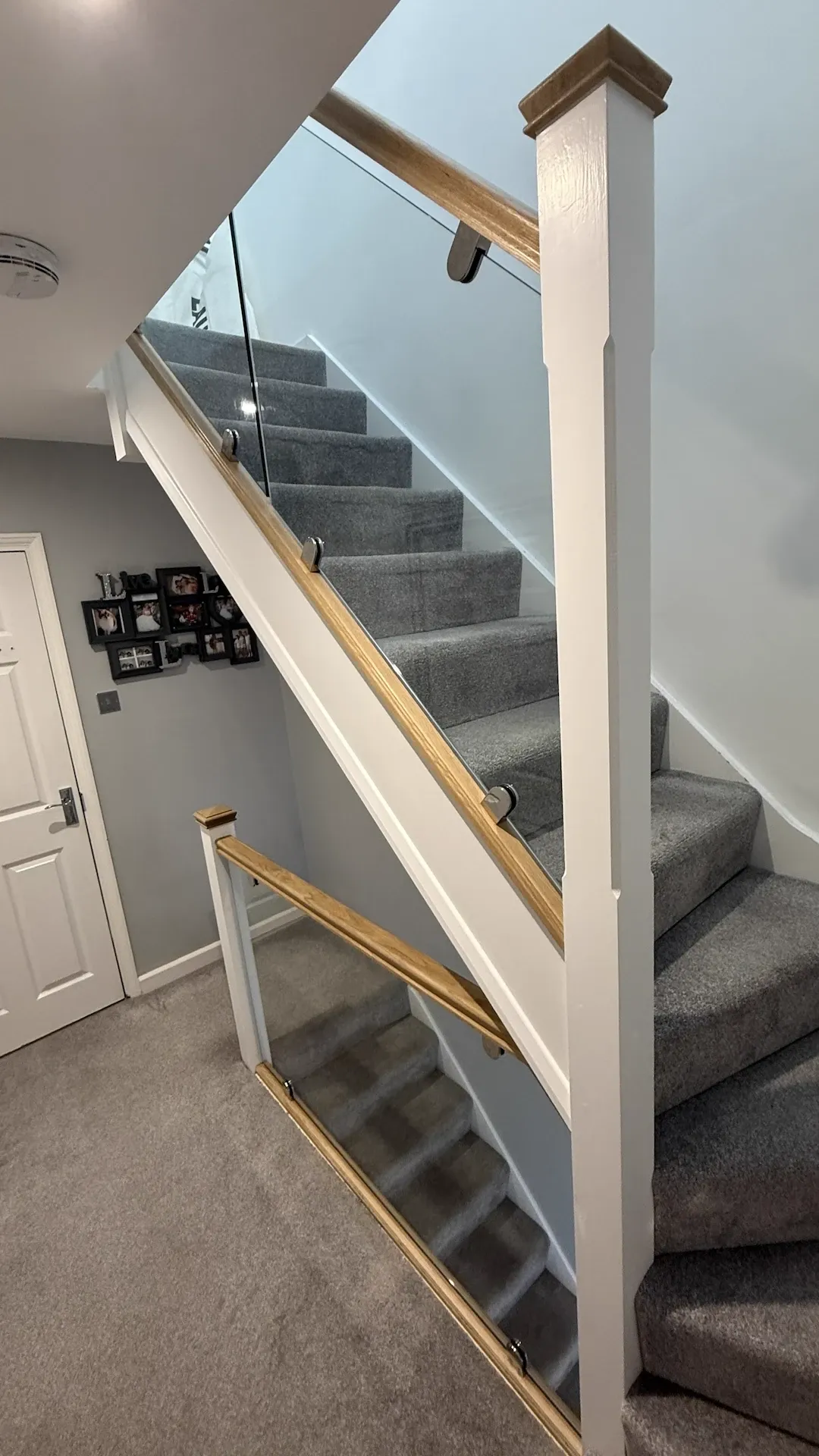 Modern glass staircase renovation in Kent with oak handrails, white posts and expertly installed balustrades by staircase specialists.