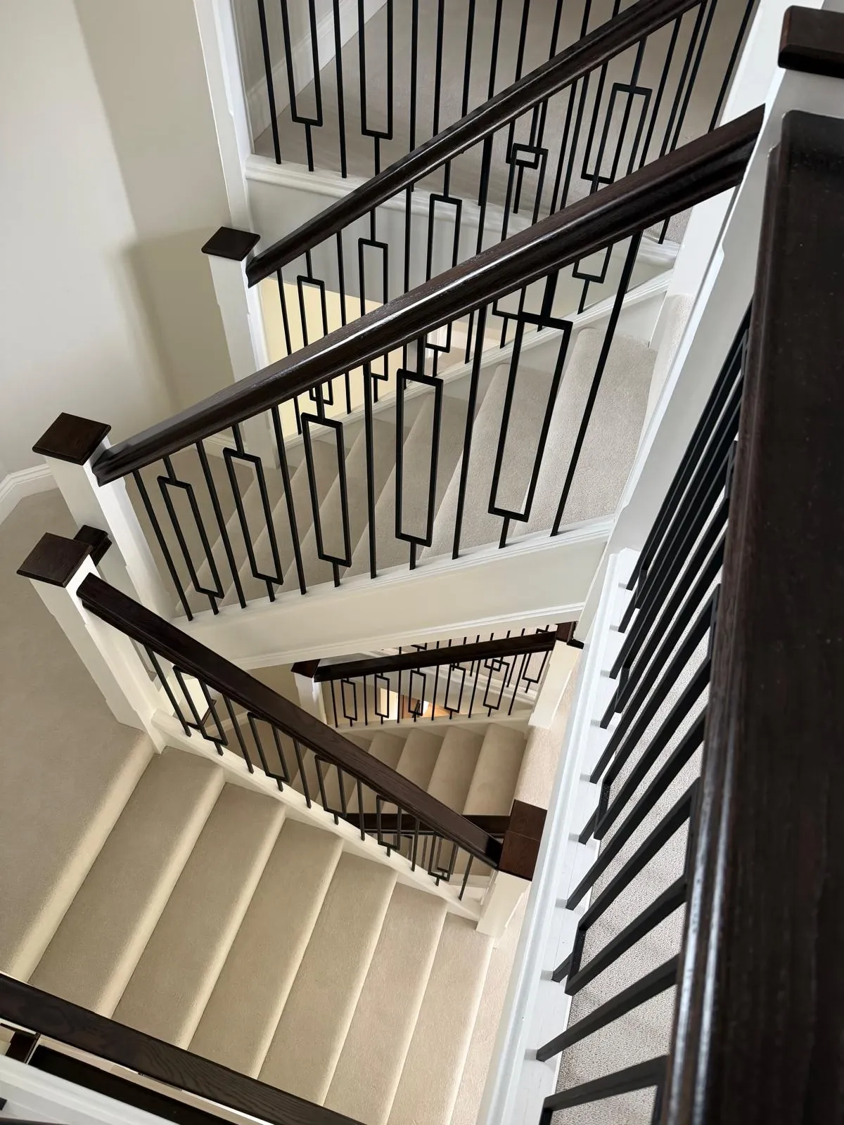 Bespoke Kent staircases with geometric metal balustrades and dark rails, precision fitted by staircase specialists