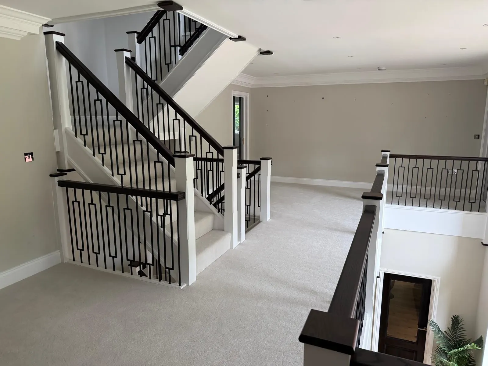 Bespoke Kent staircases with black metal balustrades and dark rails, fitted with precision by staircase specialists