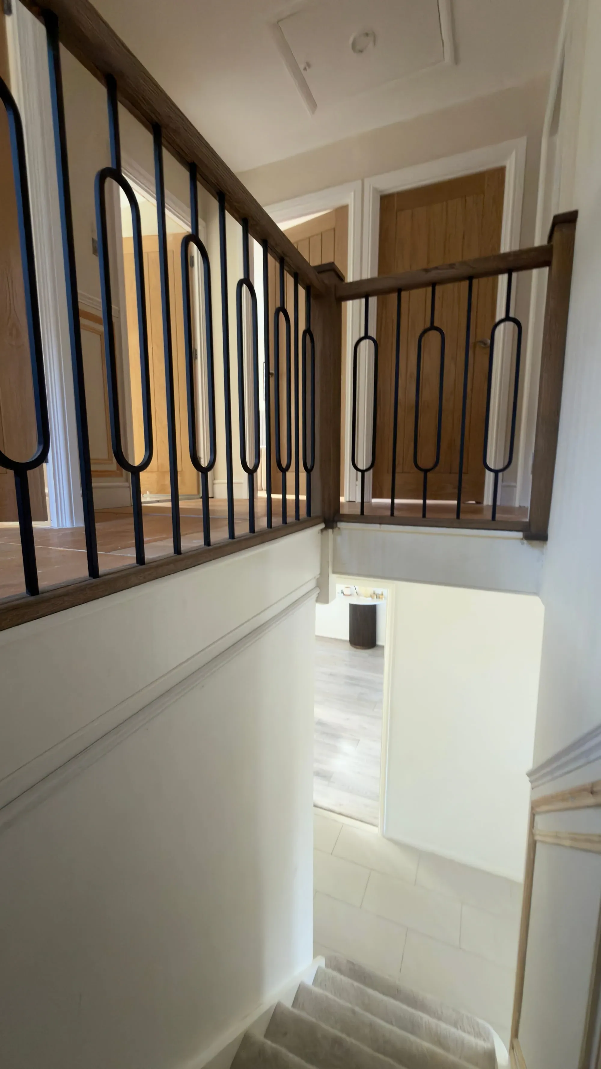 View up the stairs towards the original dark timber landing balustrade, decorative black spindles and white landing apron.
