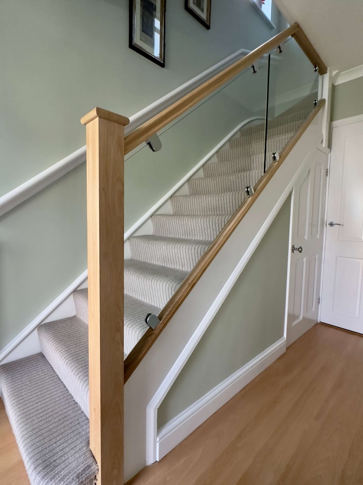 Modern oak and glass staircase with sleek fittings, designed to enhance safety and style in a Kent home interior.