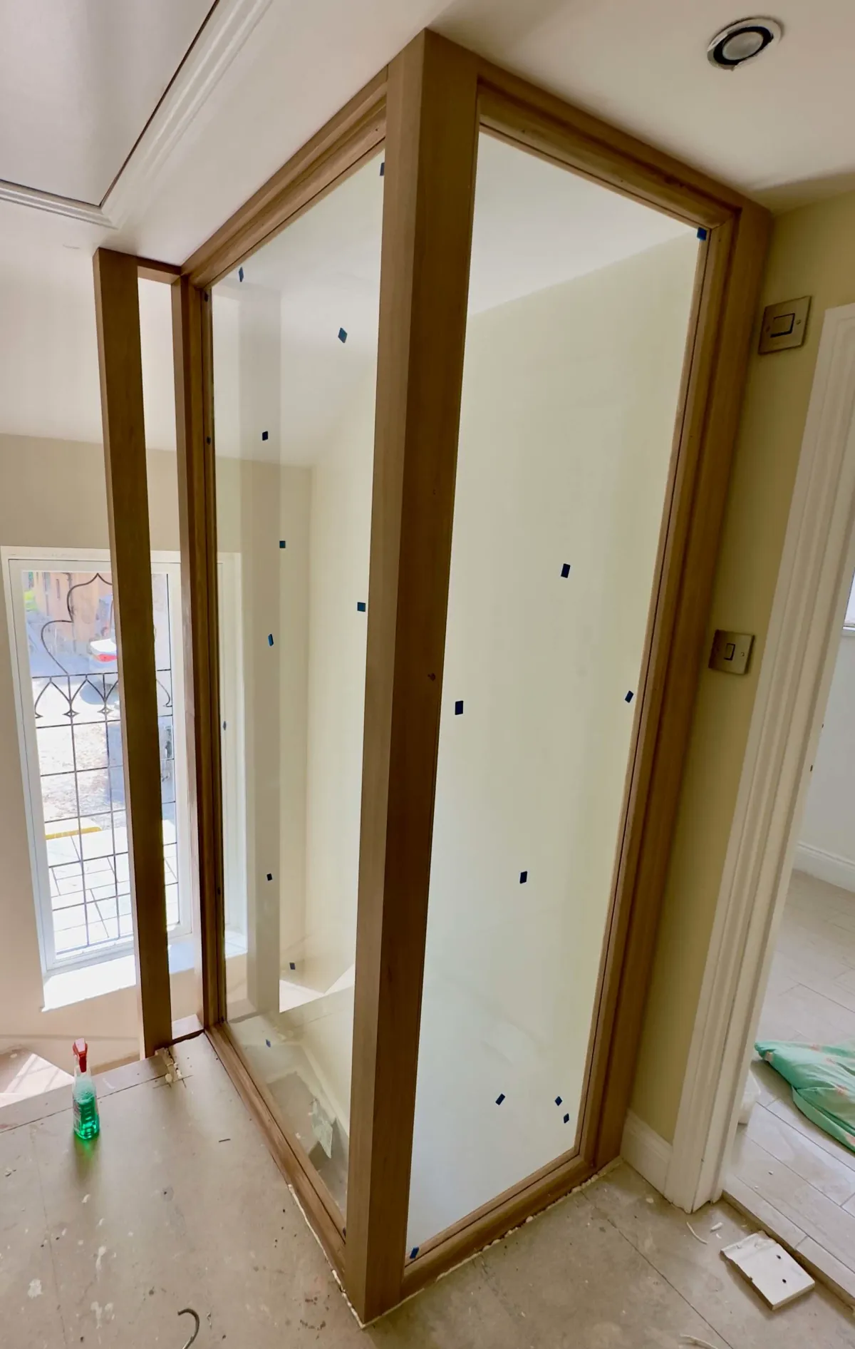 Timber-framed balustrade under construction around a staircase opening, with natural light from a nearby window.