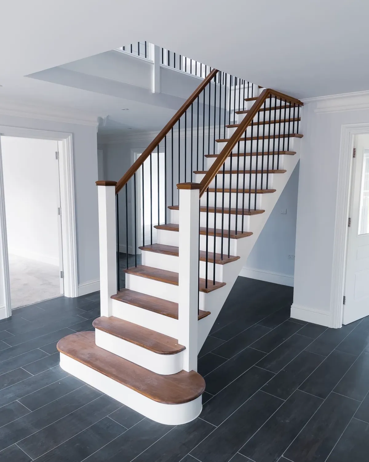 Modern wooden staircase with black balustrades by Kent staircase specialists delivering bespoke staircase design and renovation.